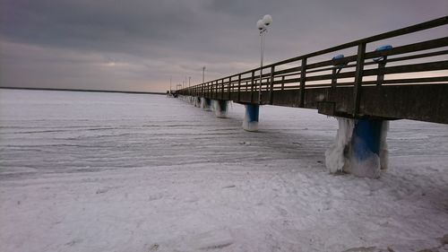 Bridge over sea against sky during winter