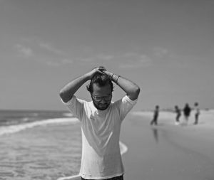 Full length of man standing on beach against sky