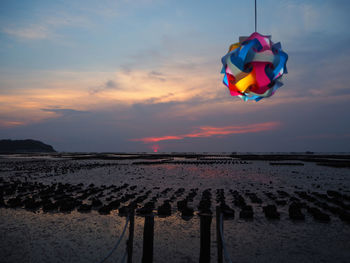 Multi colored umbrellas on beach against sky during sunset