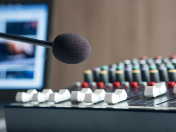 Close-up of microphone and sound mixer in studio