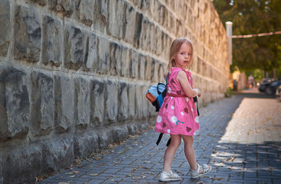 Full length of a girl standing on footpath