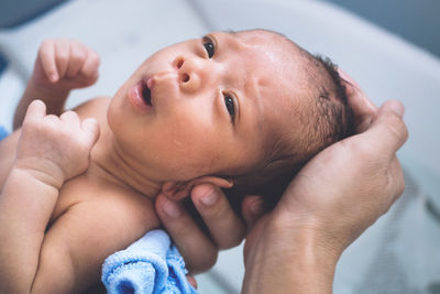 Cropped hand of parent touching baby boy head