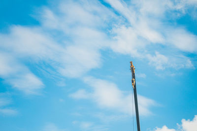 Low angle view of communications tower against blue sky