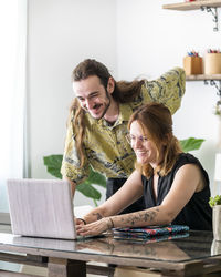 Male and female creative designers drawing sketches on graphic tablets while working together on project in workspace