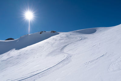 Scenic view of snowcapped mountain against blue sky