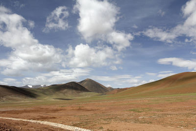 Beautiful mountains and red plateau meadows under the blue sky and white clouds