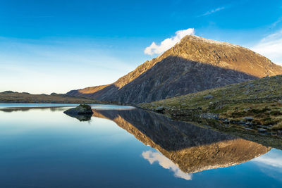 Scenic view of lake and mountains against blue sky