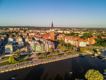 High angle view of illuminated city by river against sky