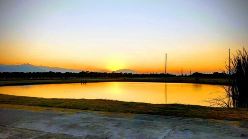 Scenic view of lake against orange sky