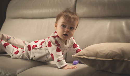 Portrait of cute baby girl on bed at home