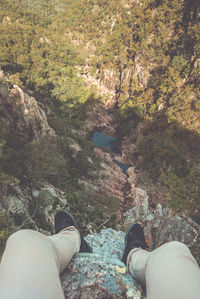Low section of man relaxing on rock