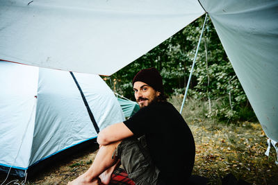 Beautiful young woman standing against tent