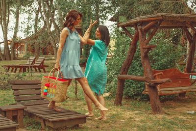 Woman standing in basket against trees