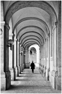 Rear view of man walking in historic building