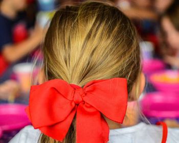 Rear view of girl with red tied bow