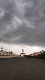 Building on field against cloudy sky