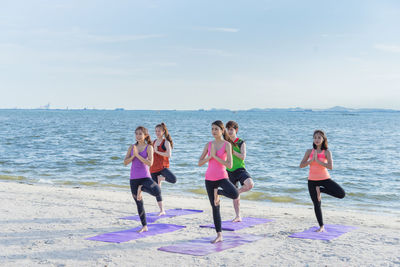 People enjoying at beach against sky