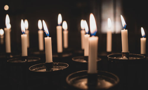 Close-up of illuminated candles in church