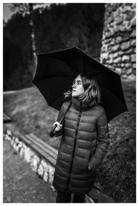 Girl with umbrella standing outdoors
