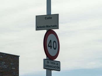 Low angle view of road sign against sky