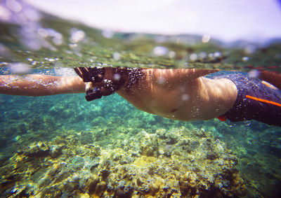 Side view of man snorkeling in sea on sunny day