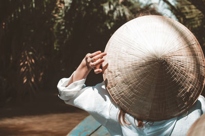 Midsection of person holding umbrella against trees