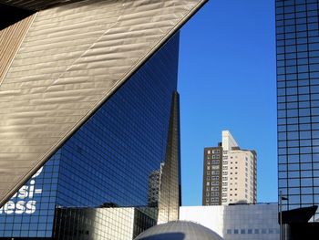 Low angle view of modern buildings against clear blue sky
