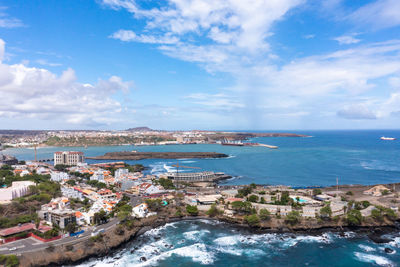High angle view of townscape by sea against sky