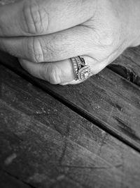 Close-up of cropped hand on wooden wall