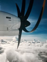 Airplane flying over cloudscape against sky