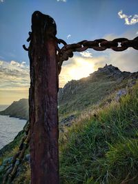 View of wooden post on field against sky