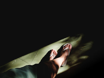 Low section of woman legs against black background