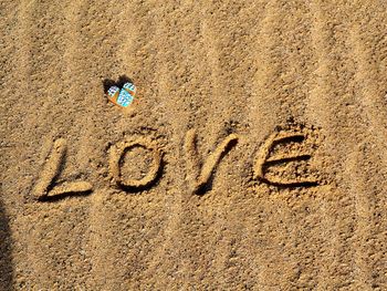 Close-up of text on sand