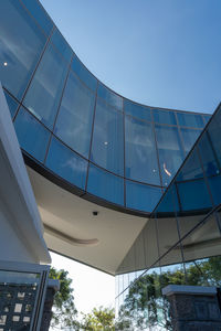 Low angle view of modern building against clear blue sky