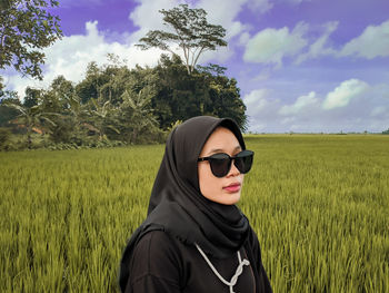 Young woman wearing sunglasses on field