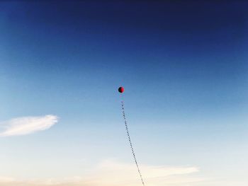 Low angle view of balloons against sky during sunset
