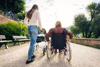 Rear view of people walking on road