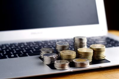 Close-up of coins on laptop 