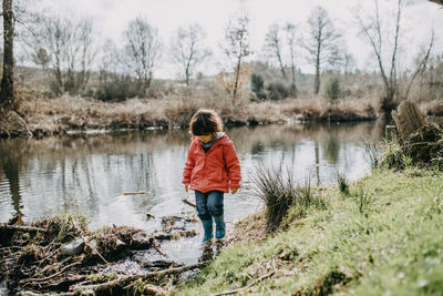 Full length of boy standing on lake against trees