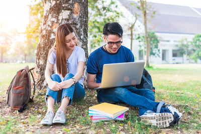 University students using laptop at park