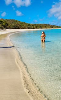 Rear view of woman standing at beach
