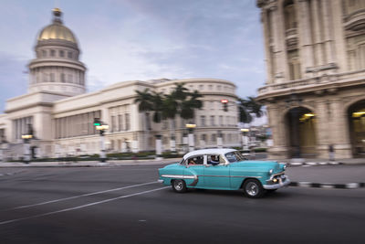 Cars on road by buildings in city