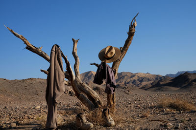 Rear view of woman standing on sand at desert