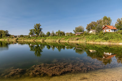 Scenic view of lake by building against sky