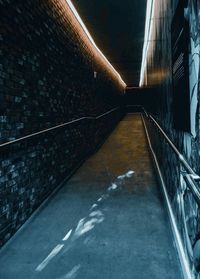 Empty footpath amidst buildings in tunnel