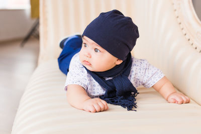 High angle view of son lying on sofa