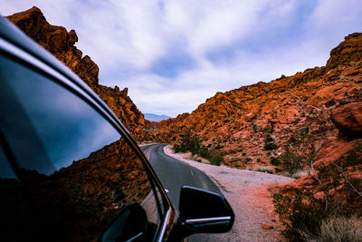 Road by mountains against sky