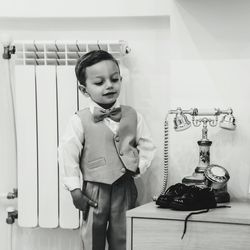 Portrait of young woman standing against wall