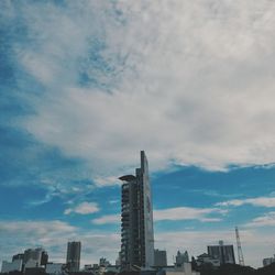 Low angle view of crane against cloudy sky