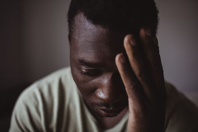 Close-up of sad man holding head in hand